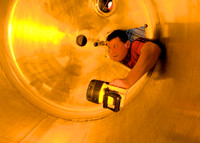Brewery technician inspects a tank.